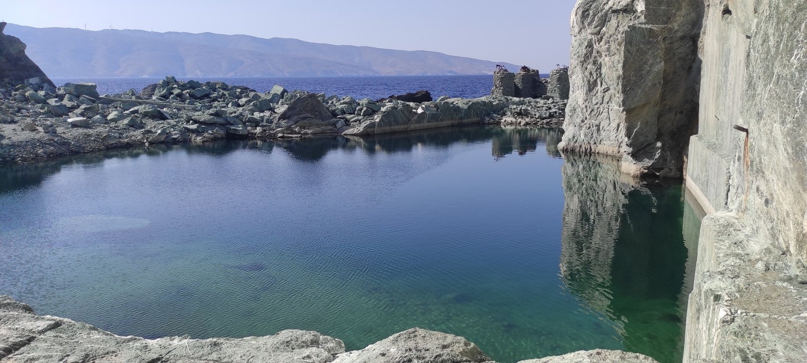 Η «πισίνα» του λατομείου πράσινου μαρμάρου της Τήνου, με θέα τη θάλασσα και την Άνδρο απέναντι