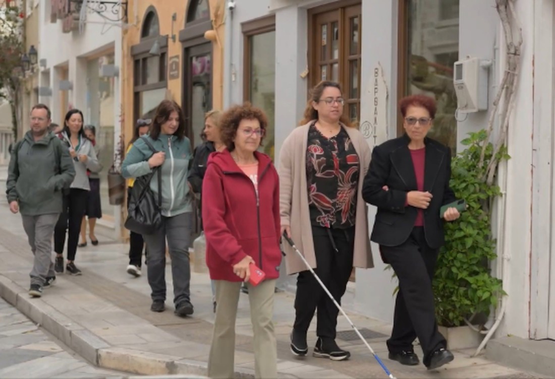 Ομάδα ανθρώπων περπατά σε δρόμο της Ερμούπολης — καρέ από το ντοκιμαντέρ