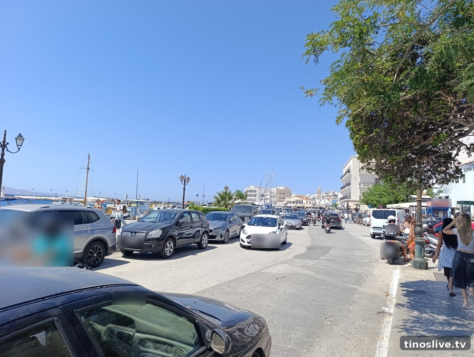 Η παραλία της Χώρας της Τήνου το καλοκαίρι, γεμάτη αυτοκίνητα και μηχανάκια