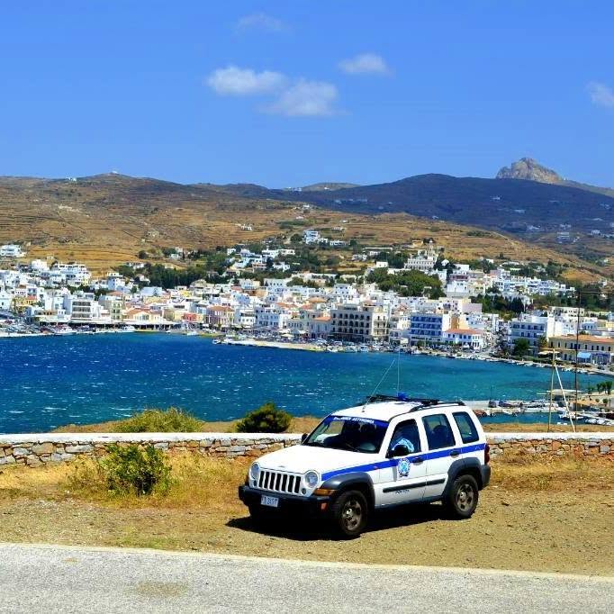 Περιπολικό της Ελληνικής Αστυνομίας με φόντο τη Χώρα της Τήνου και το Εξώμβουργο
