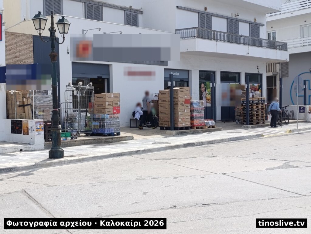 Παλέτες με εμπορεύματα πάνω στο πεζοδρόμιο μπροστά σε σούπερ μάρκετ της Τήνου, φωτογραφία αρχείου, καλοκαίρι 2026