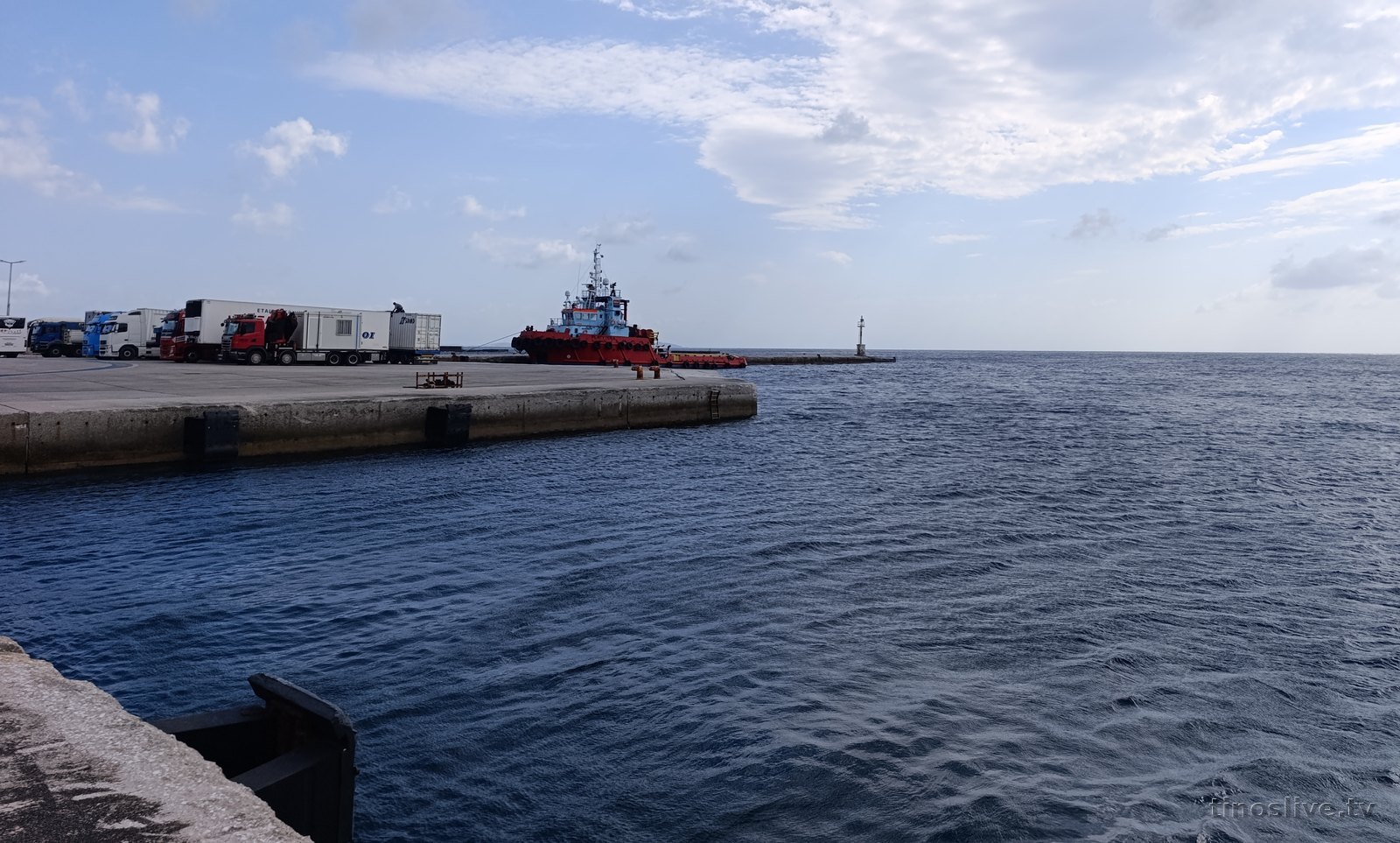 Το ρυμουλκό ΠΛΑΤΥΤΕΡΑ δεμένο στο λιμάνι της Τήνου με φορτηγά να περιμένουν στον προβλήτα