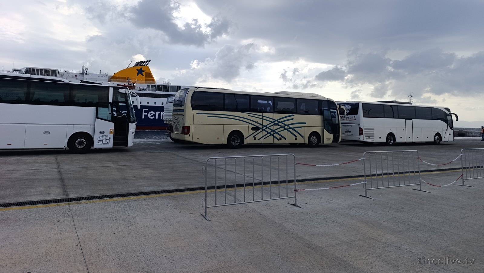 Πούλμαν εκδρομέων παραταγμένα στο λιμάνι της Τήνου περιμένοντας το πλοίο