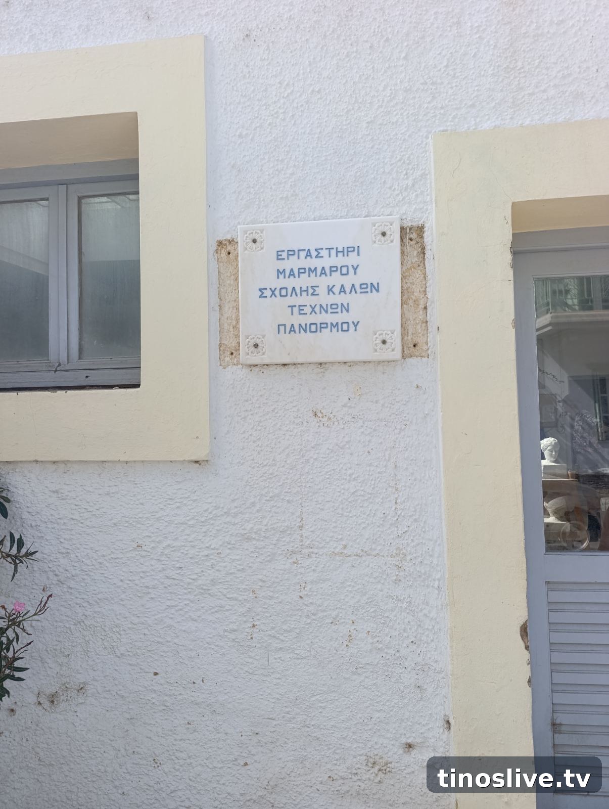 Μαρμάρινη πινακίδα με γαλάζια γράμματα: Εργαστήρι Μαρμάρου Σχολής Καλών Τεχνών Πανόρμου