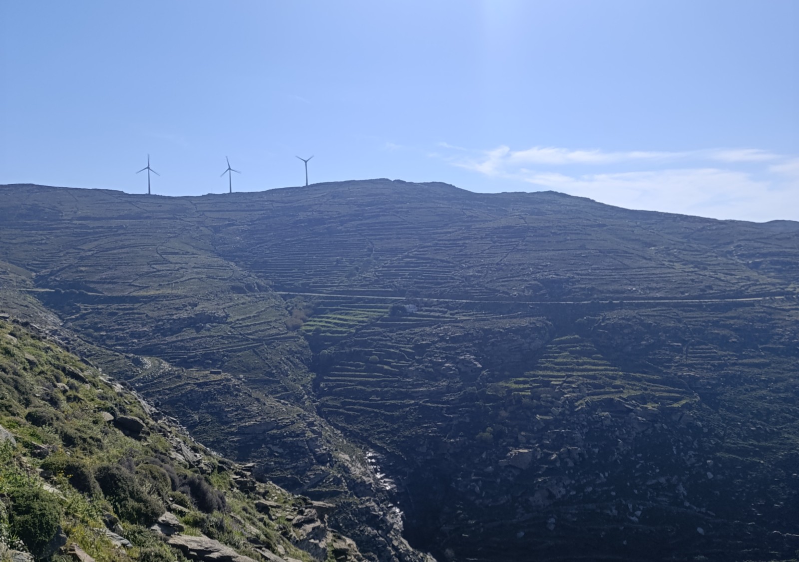 Οι τρεις ανεμογεννήτριες στην κορυφογραμμή του Πολέμου Κάμπου, πάνω από τις αναβαθμίδες, στην Τήνο